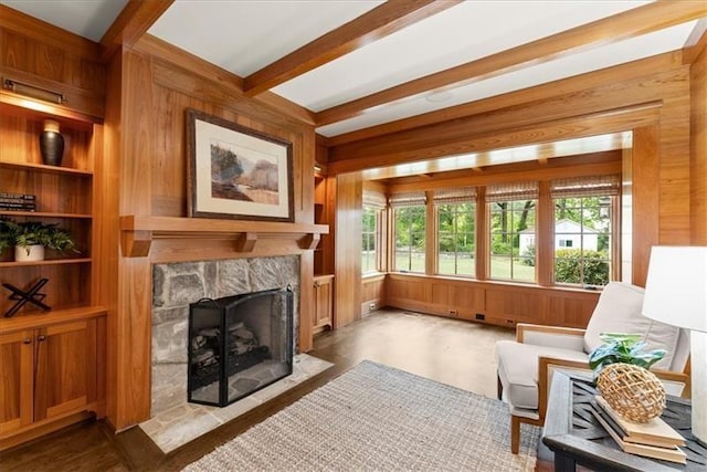 interior space with beam ceiling and a stone fireplace