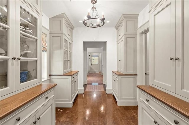 mudroom featuring dark wood-type flooring and a notable chandelier