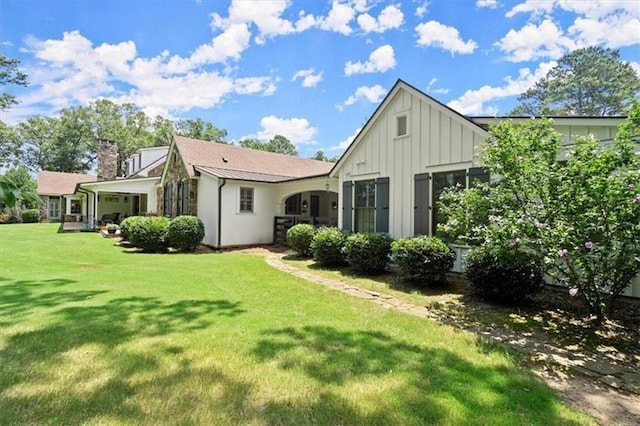 rear view of house featuring a lawn