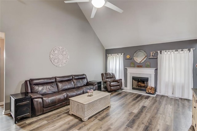 living room featuring wood-type flooring, ceiling fan, and lofted ceiling