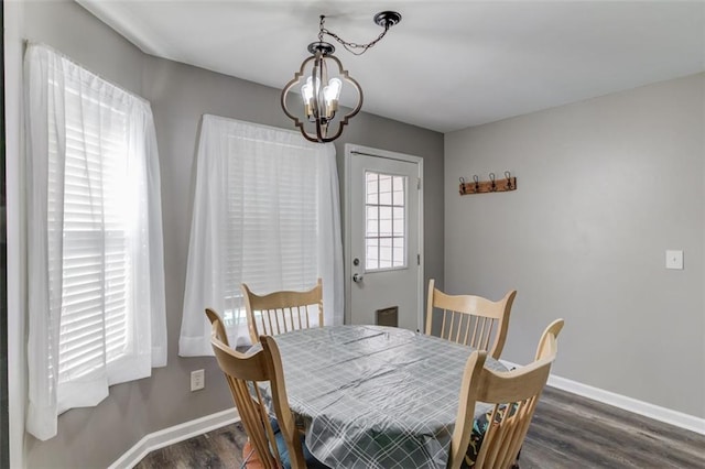 dining area featuring dark hardwood / wood-style flooring and a chandelier