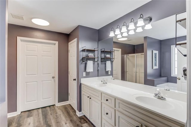 bathroom with wood-type flooring, vanity, and shower with separate bathtub