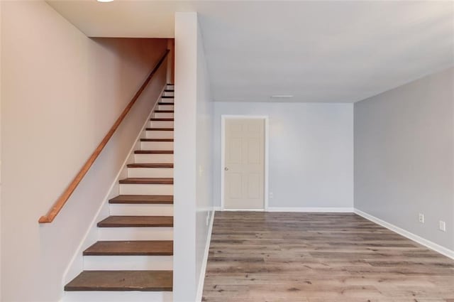 staircase with hardwood / wood-style floors