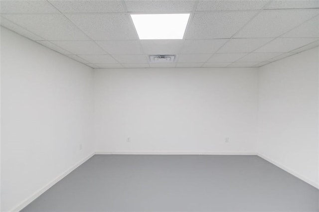 spare room with concrete floors and a paneled ceiling