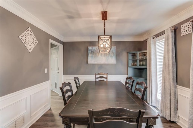 dining area with crown molding and dark wood-type flooring