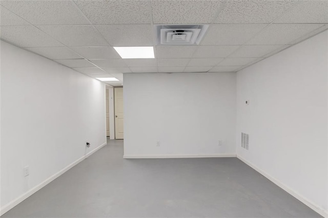 empty room featuring a paneled ceiling and concrete flooring