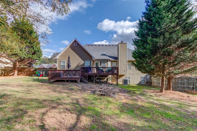 rear view of house featuring cooling unit, a deck, and a yard