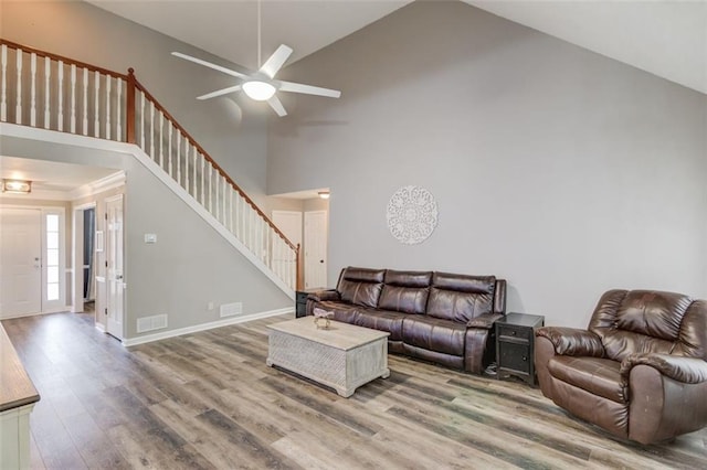 living room featuring hardwood / wood-style floors, high vaulted ceiling, and ceiling fan