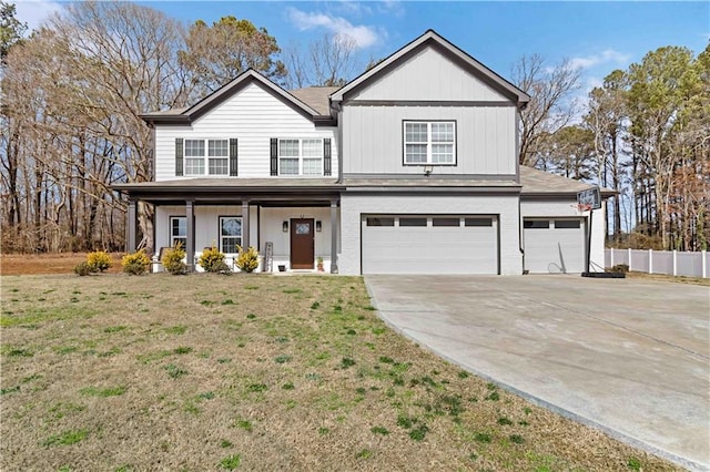 view of front of property with brick siding, concrete driveway, a front yard, fence, and a garage