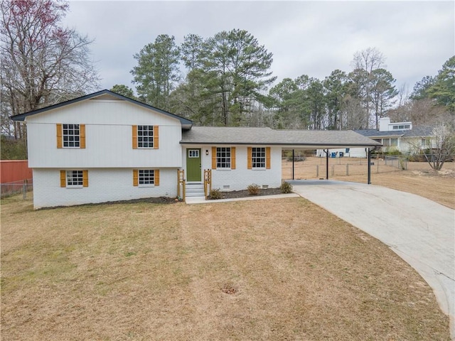 split level home with brick siding, fence, driveway, a carport, and a front yard