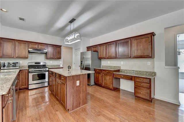 580 Hammersmith Dr, Suwanee, GA 30024 - kitchen with appliances with stainless steel finishes, under cabinet range hood, light wood-style floors, light stone counters, and a center island