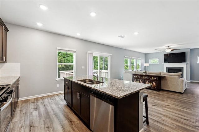 519 Magnolia Dr, Dawsonville, GA 30534 - kitchen featuring appliances with stainless steel finishes, a sink, a fireplace, light wood finished floors, and recessed lighting