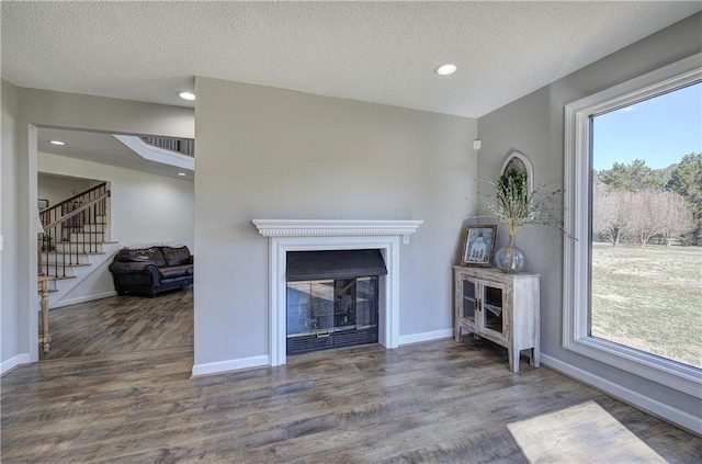 317 Shenandoah Dr NE, Calhoun, GA 30701 - living area featuring wood finished floors, baseboards, stairs, recessed lighting, and a glass covered fireplace