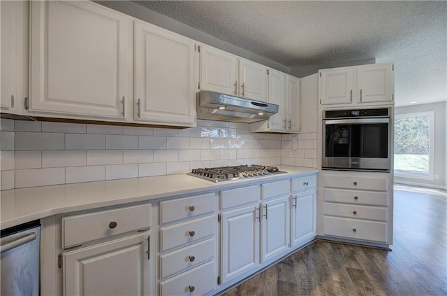 317 Shenandoah Dr NE, Calhoun, GA 30701 - kitchen featuring stainless steel appliances, under cabinet range hood, dark wood-style floors, white cabinets, and a textured ceiling