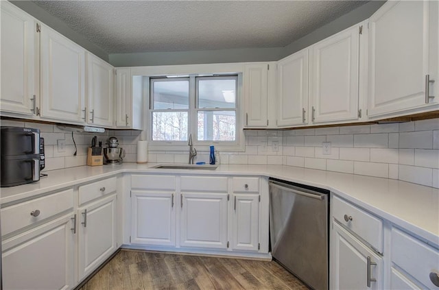 317 Shenandoah Dr NE, Calhoun, GA 30701 - kitchen featuring stainless steel dishwasher, white cabinets, backsplash, light countertops, and a textured ceiling