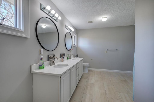 317 Shenandoah Dr NE, Calhoun, GA 30701 - full bath featuring double vanity, a textured ceiling, toilet, and baseboards