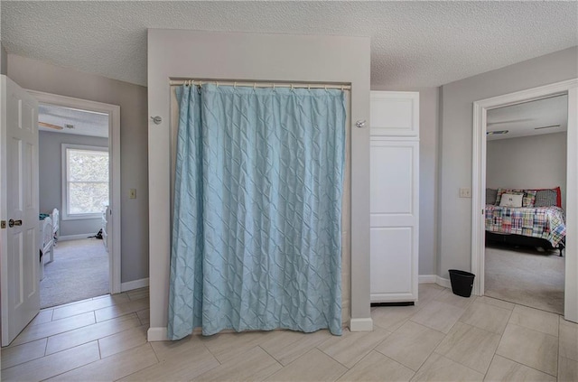 317 Shenandoah Dr NE, Calhoun, GA 30701 - ensuite bathroom with a textured ceiling, baseboards, and curtained shower