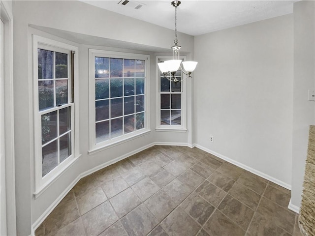 unfurnished dining area featuring a chandelier