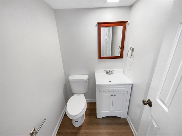 bathroom with vanity, wood-type flooring, and toilet