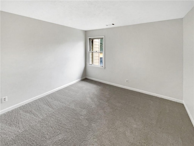 unfurnished room featuring dark carpet