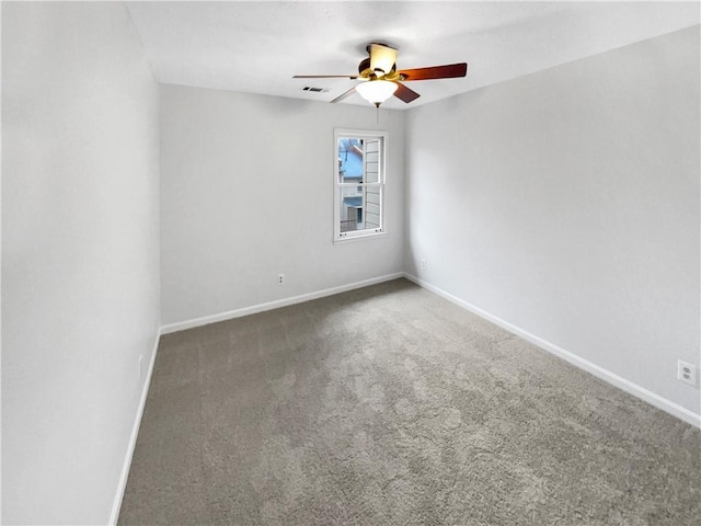 empty room featuring dark colored carpet and ceiling fan