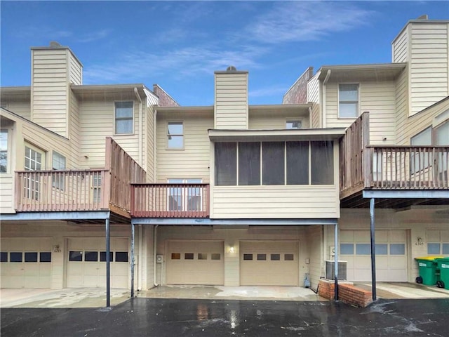 rear view of house with a garage and cooling unit