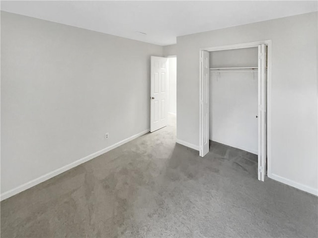 unfurnished bedroom featuring a closet and dark colored carpet