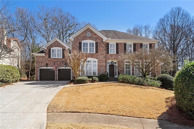 colonial house with concrete driveway, a garage, and brick siding