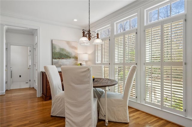 dining room with recessed lighting, wood finished floors, an inviting chandelier, and ornamental molding