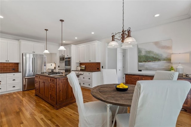 dining area featuring crown molding, recessed lighting, and light wood finished floors