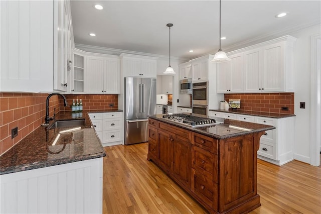 kitchen with a sink, a center island, light wood-type flooring, and stainless steel appliances