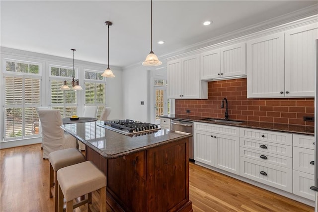 kitchen featuring decorative backsplash, plenty of natural light, appliances with stainless steel finishes, and a sink