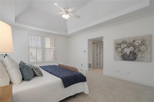 bedroom featuring a tray ceiling, visible vents, baseboards, and light colored carpet