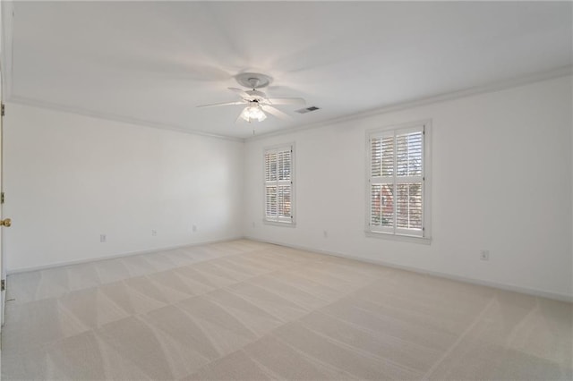 unfurnished room with ceiling fan, visible vents, light colored carpet, and ornamental molding