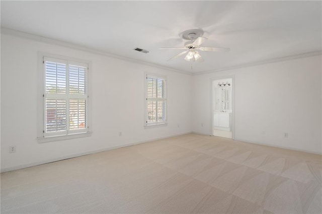 empty room with visible vents, light colored carpet, a healthy amount of sunlight, and ornamental molding