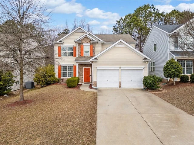 traditional home with an attached garage, concrete driveway, central AC, and stone siding