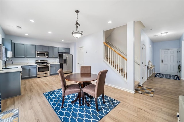 dining room featuring light wood finished floors, stairs, visible vents, and recessed lighting