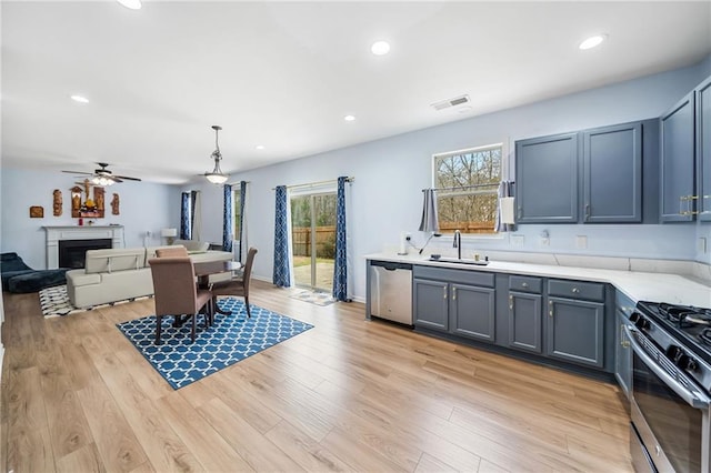 interior space featuring appliances with stainless steel finishes, light wood-type flooring, visible vents, and a sink