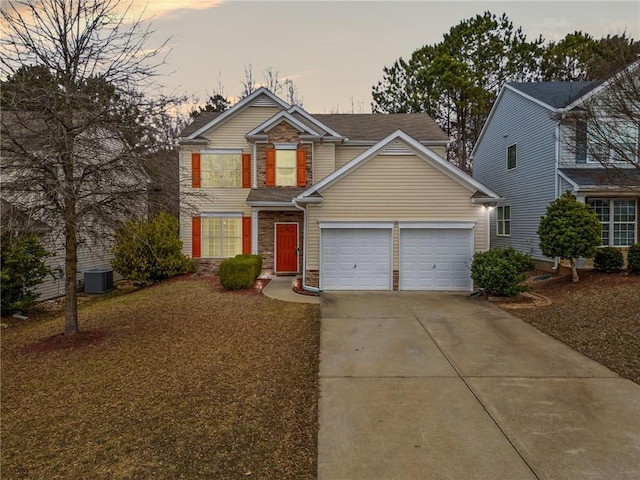 traditional-style home featuring a garage, concrete driveway, stone siding, and cooling unit