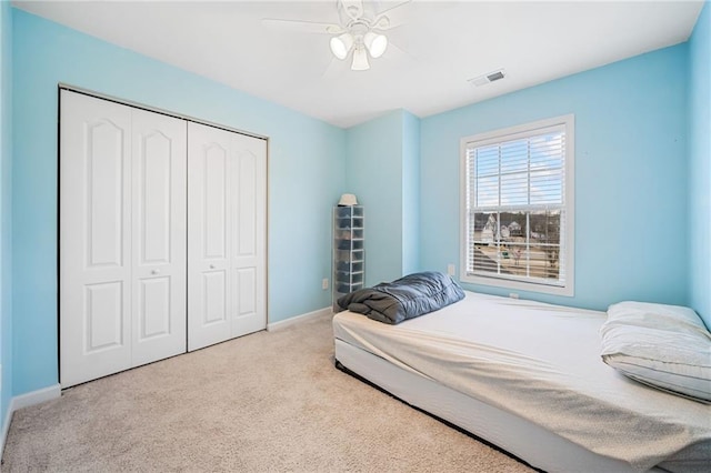 carpeted bedroom featuring a ceiling fan, a closet, visible vents, and baseboards