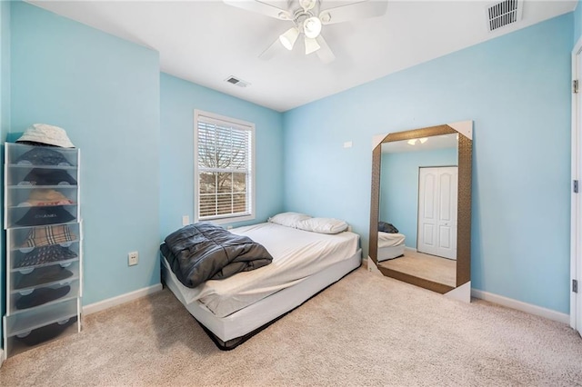 carpeted bedroom with visible vents, ceiling fan, and baseboards