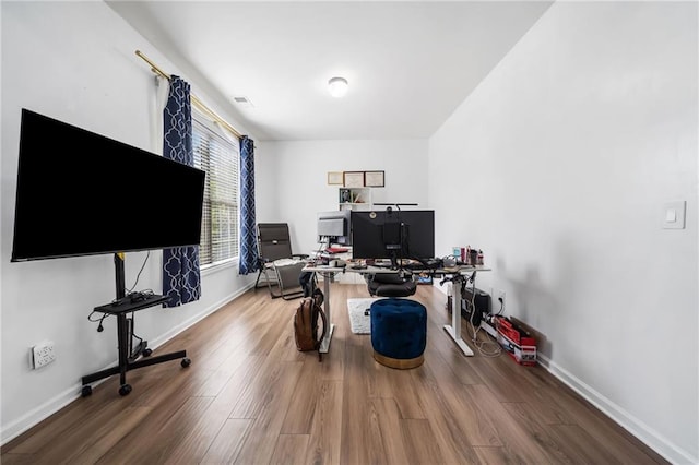 office space featuring visible vents, baseboards, and wood finished floors