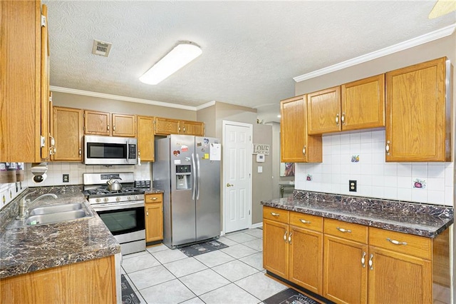 kitchen with crown molding, sink, tasteful backsplash, light tile patterned flooring, and stainless steel appliances