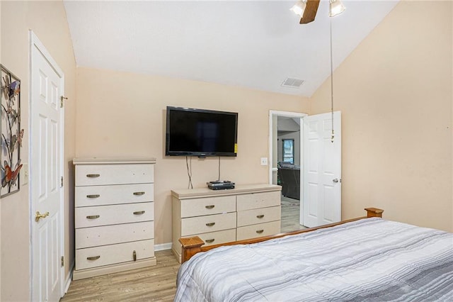 bedroom with light hardwood / wood-style floors, ceiling fan, and lofted ceiling