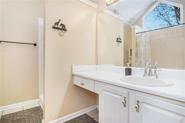 bathroom with tile patterned flooring, vanity, and lofted ceiling