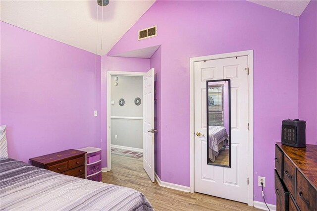 bedroom with high vaulted ceiling and light hardwood / wood-style flooring