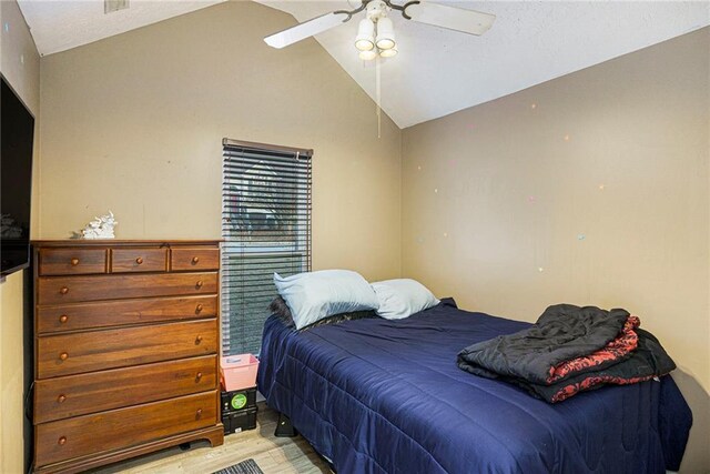 bedroom featuring ceiling fan, light hardwood / wood-style floors, and lofted ceiling