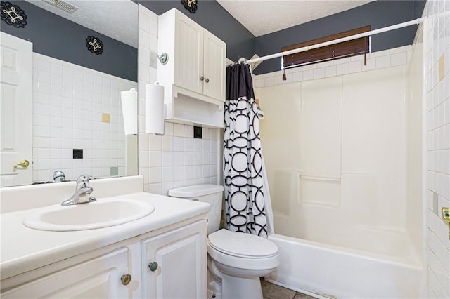 full bathroom with shower / bath combo, vanity, toilet, a textured ceiling, and tile walls