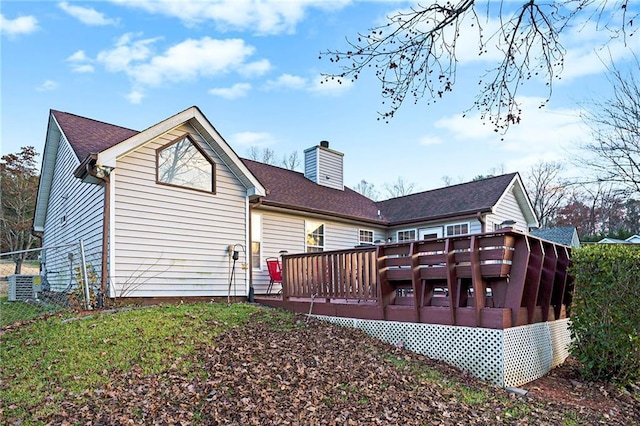 back of property with a sunroom, a deck, and central AC