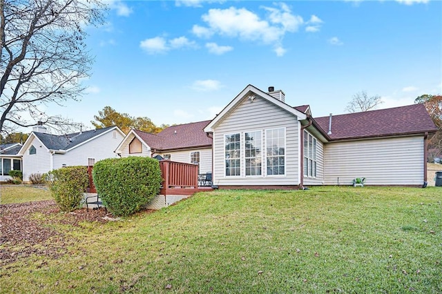 rear view of house with a yard and a wooden deck